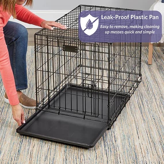 Person sliding the plastic pan out of a MidWest iCrate