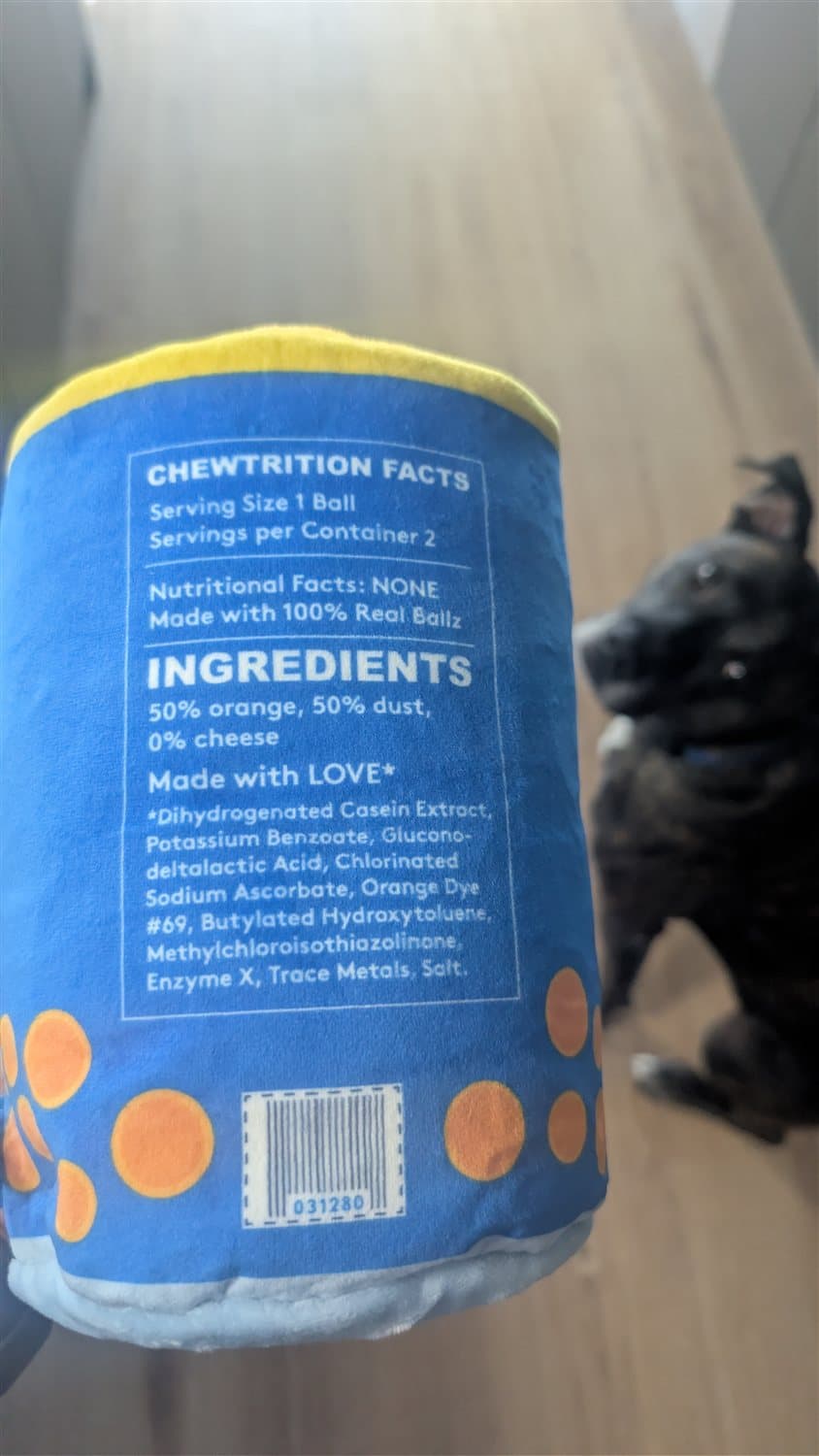 Close-up of a BarkBox Real Ballz plush toy printed like a food label