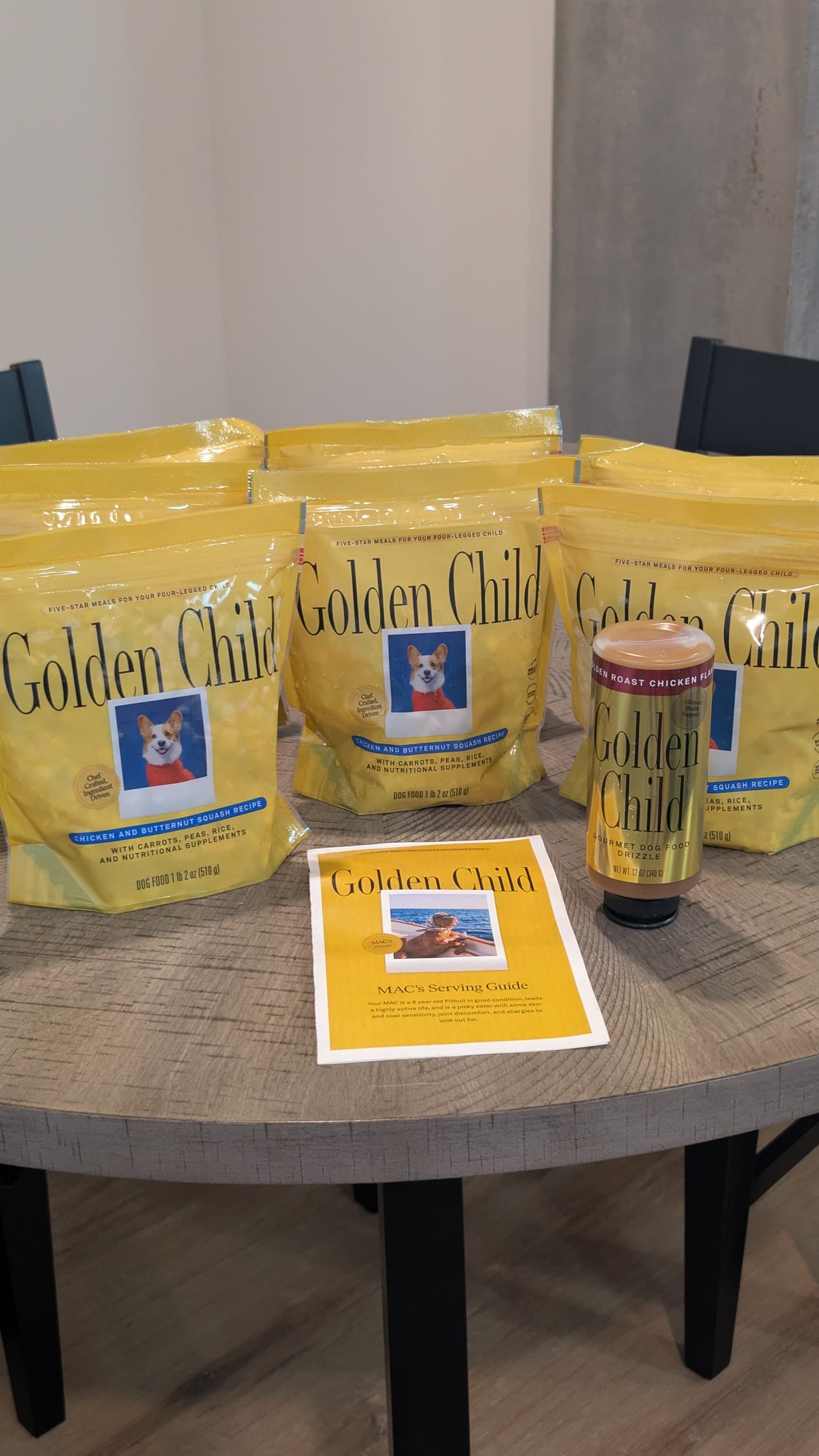 Golden Child sample pack with fresh dog food pouches, chicken Drizzle, and serving guide on a table