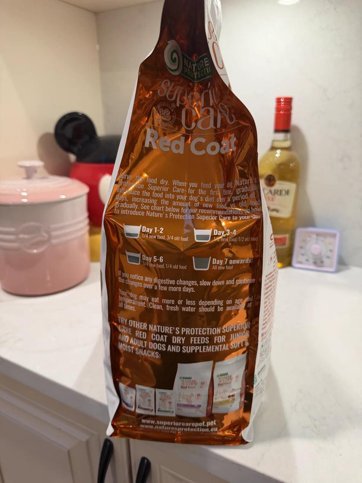 Seven-day feeding transition guide on a Nature's Protection Red Coat dog food bag