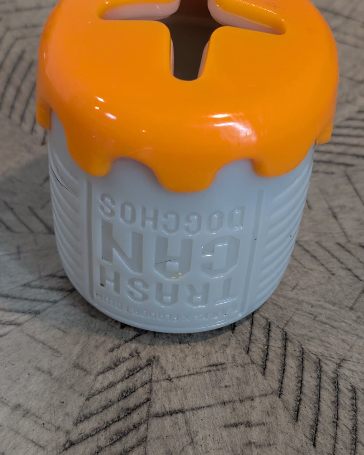 Trash Can Doggos treat-dispensing dog toy with orange lid and cross-cut opening
